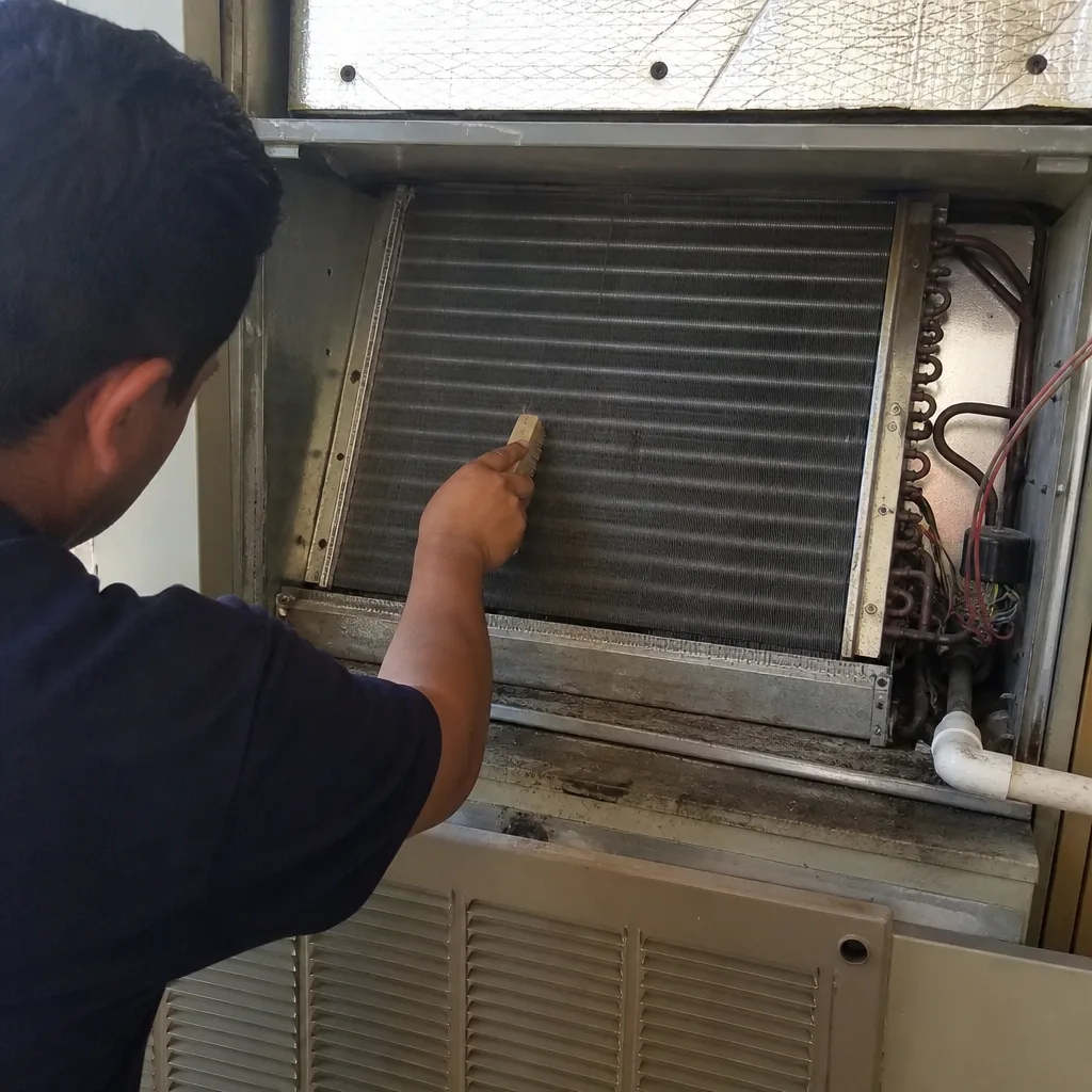 Technician performing professional HVAC coil cleaning service